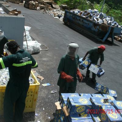 Sanitation workers crushing glass bottles