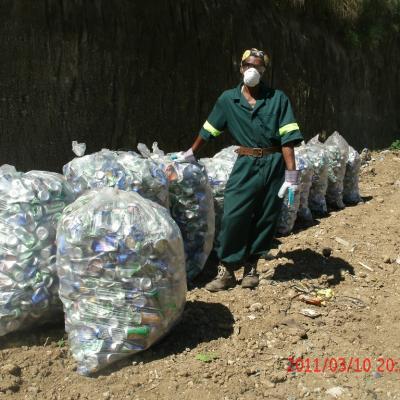 A sanitation worker sorting plastic for recycling