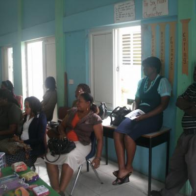 People sitting at the back of the room listening to addresses at the Goodwill Primary School Exhibition