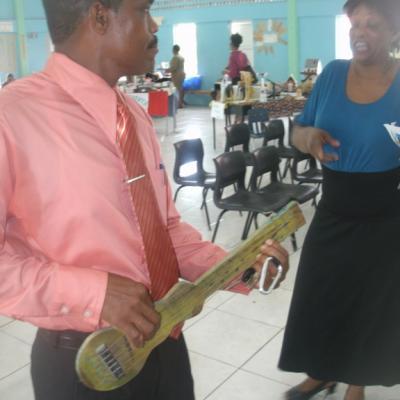 Petter St. Jean playing with a guitar made by the students