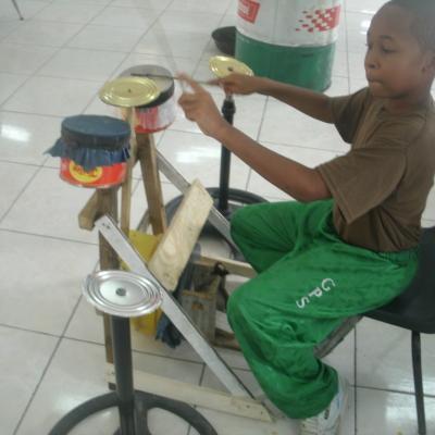 A student playing the recycled drum machine
