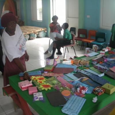 A woman displaying her craft made from recycled items