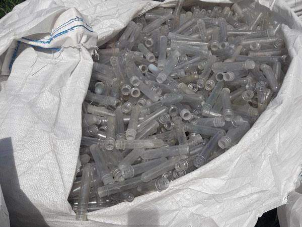 A big white bag of plastic test tubles ready for recycling