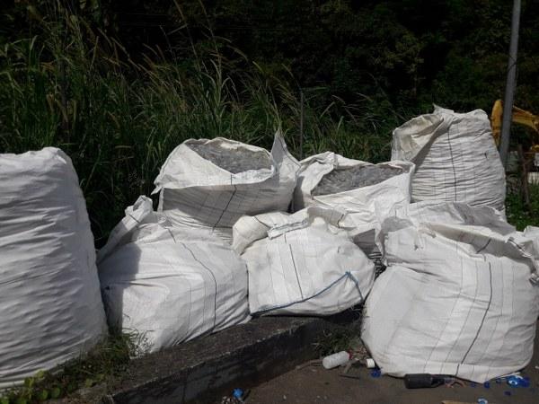 A big white bag of plastic test tubles ready for recycling