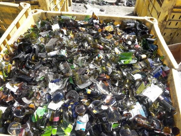 A bin of broken brown glass bottles ready for recycling