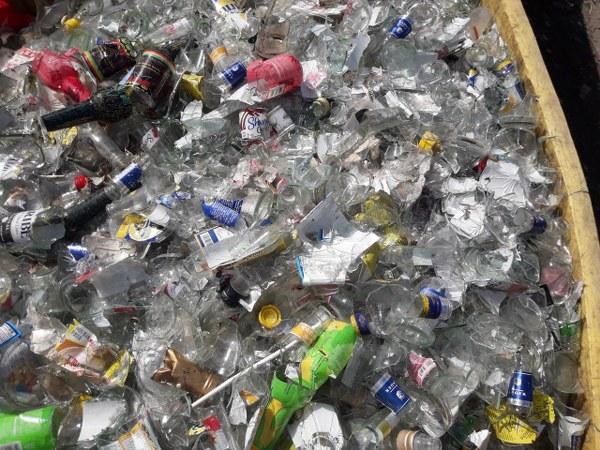 A bin of broken clear glass bottles ready for recycling