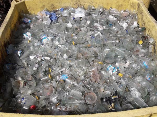 Many bins of broken glass bottles ready for recycling